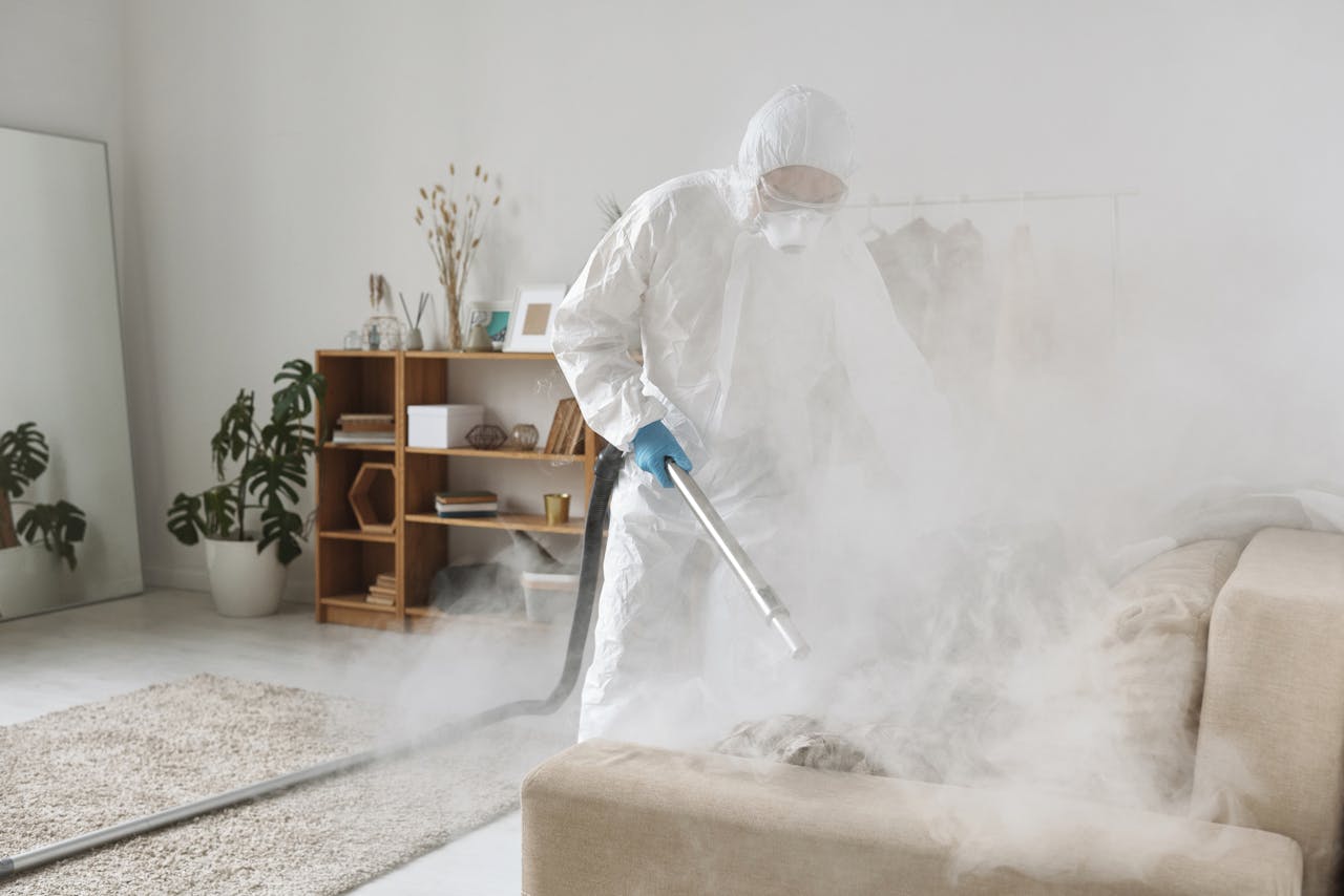 journey A person in PPE fumigates a living room for disinfection, ensuring safe environment.